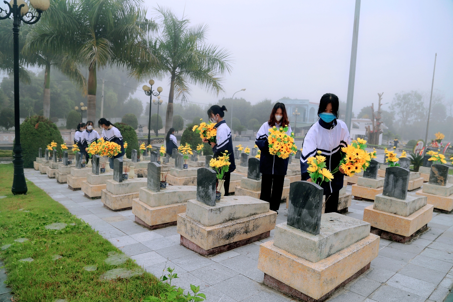 HS trường THPT Thanh Nưa chăm sóc, thay hoa tại các phần mộ liệt sĩ